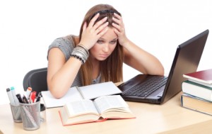 Girl, at table, having trouble studying